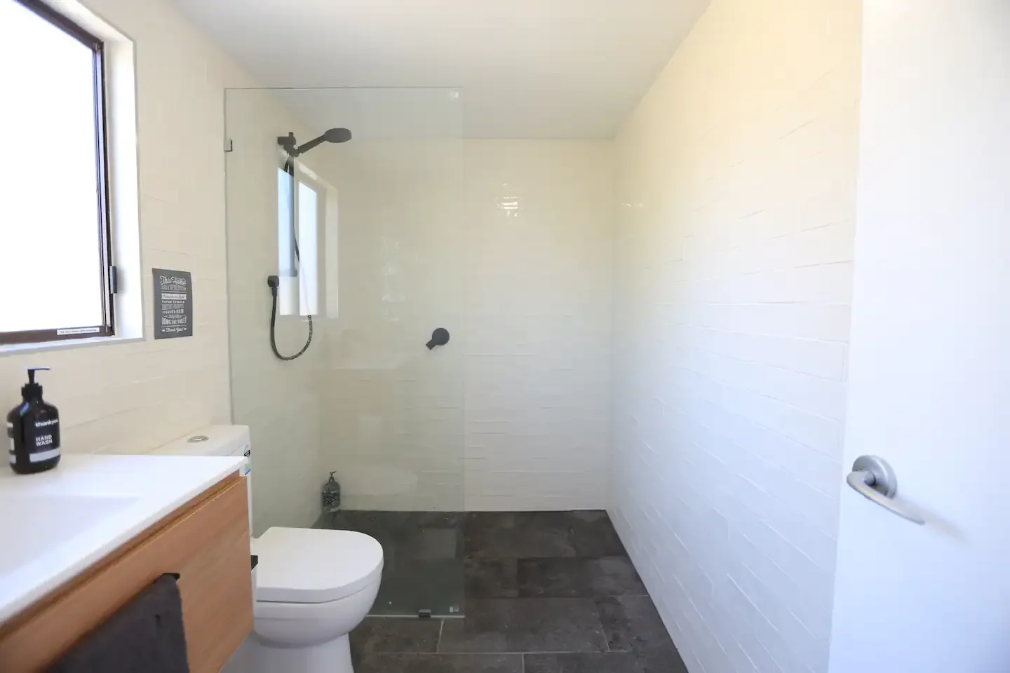 Modern white subway-tile walk-in shower with timber vanity