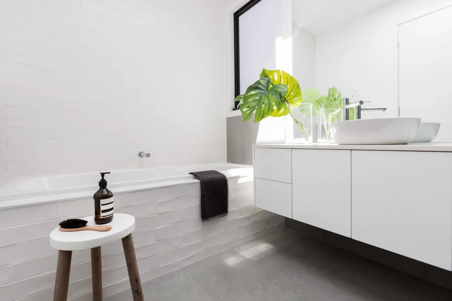 Bright bathroom renovation with floating vanity and greenery