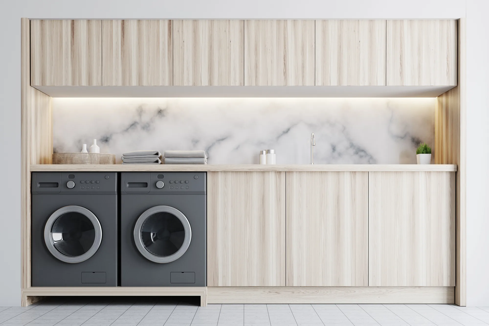 Built-in laundry with dark stacked washer and dryer and marble splashback