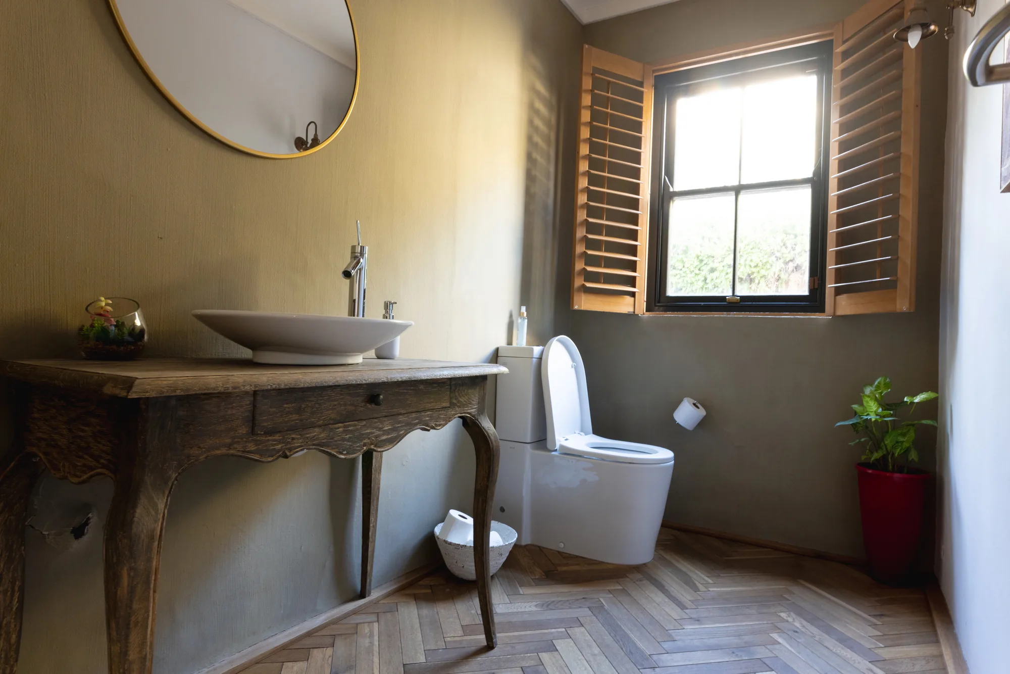 Rustic powder room renovation with round mirror and console vanity